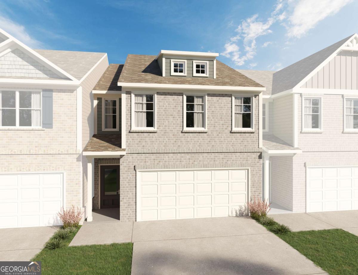 Two-story brick townhouse with a two-car garage, covered entry, and dormer.