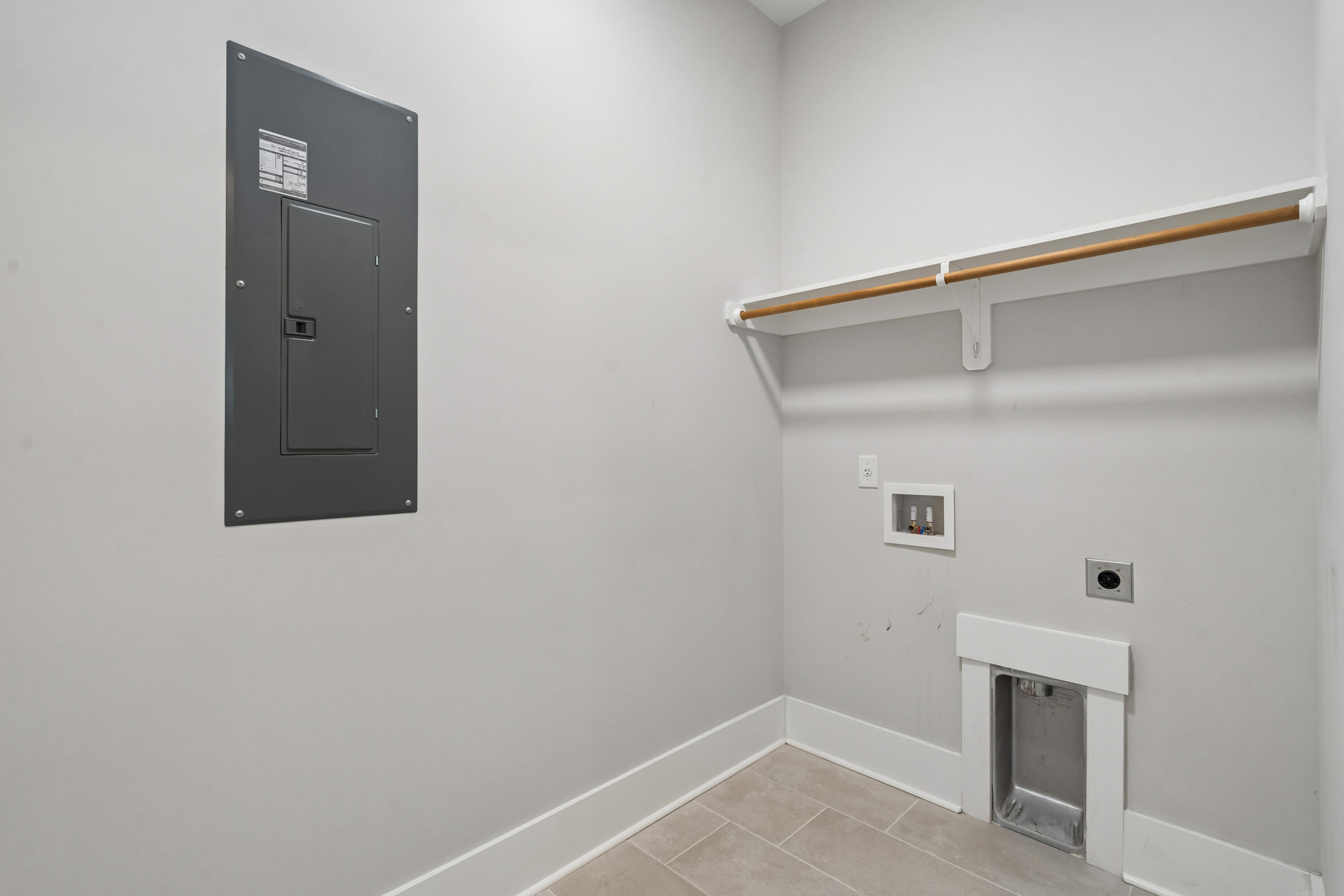 Unfurnished laundry room with washer hookups, dryer vent, and electrical panel.