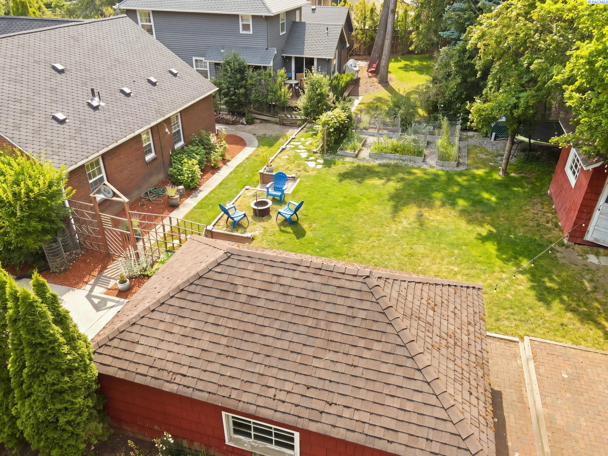 Aerial view of the brick house, backyard garden and the red garage and shed