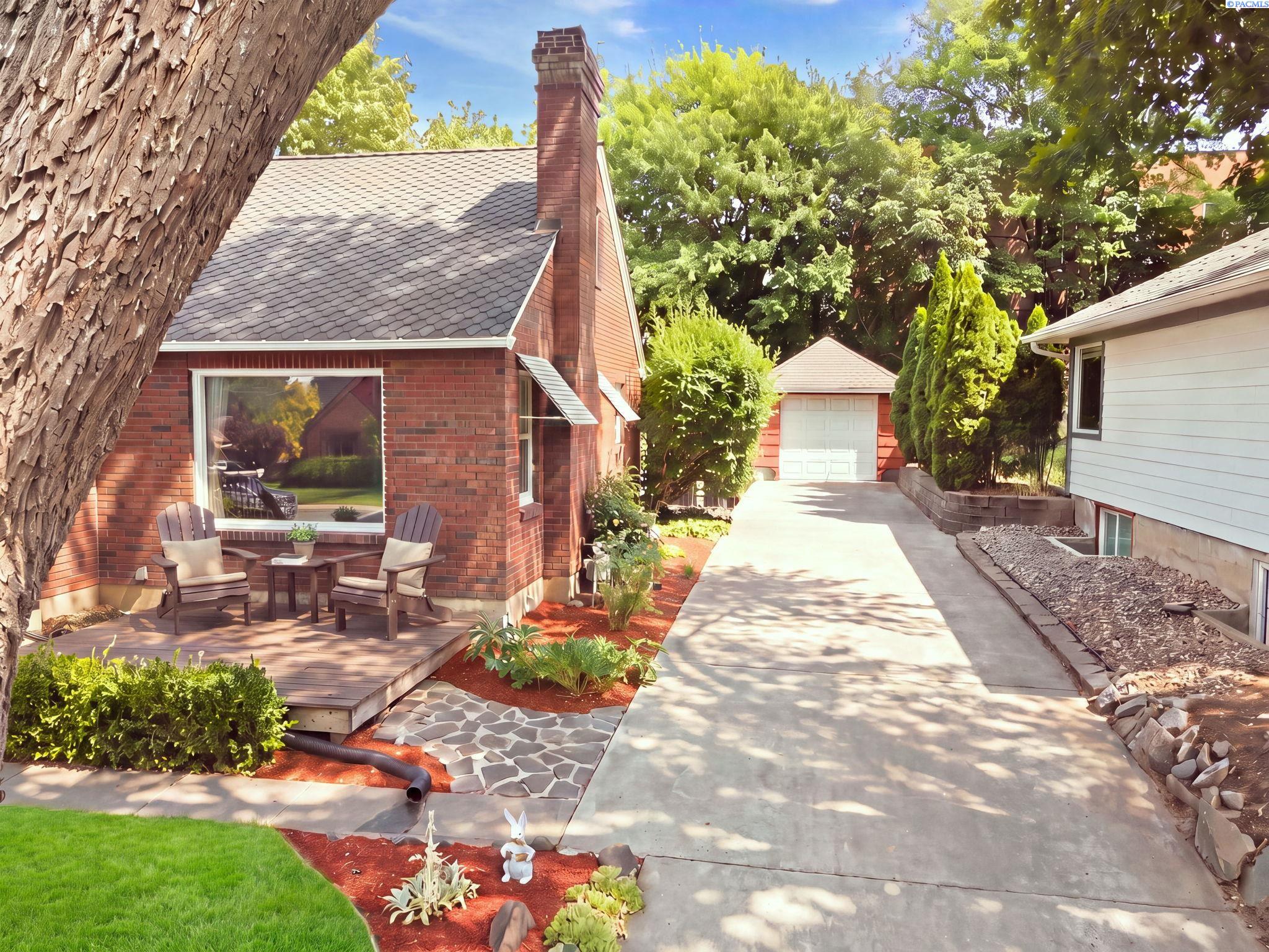 Aerial view of the front of the brick home with its driveway and detached garage