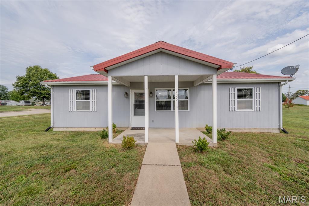 Single-story gray home with a red roof and covered front porch.