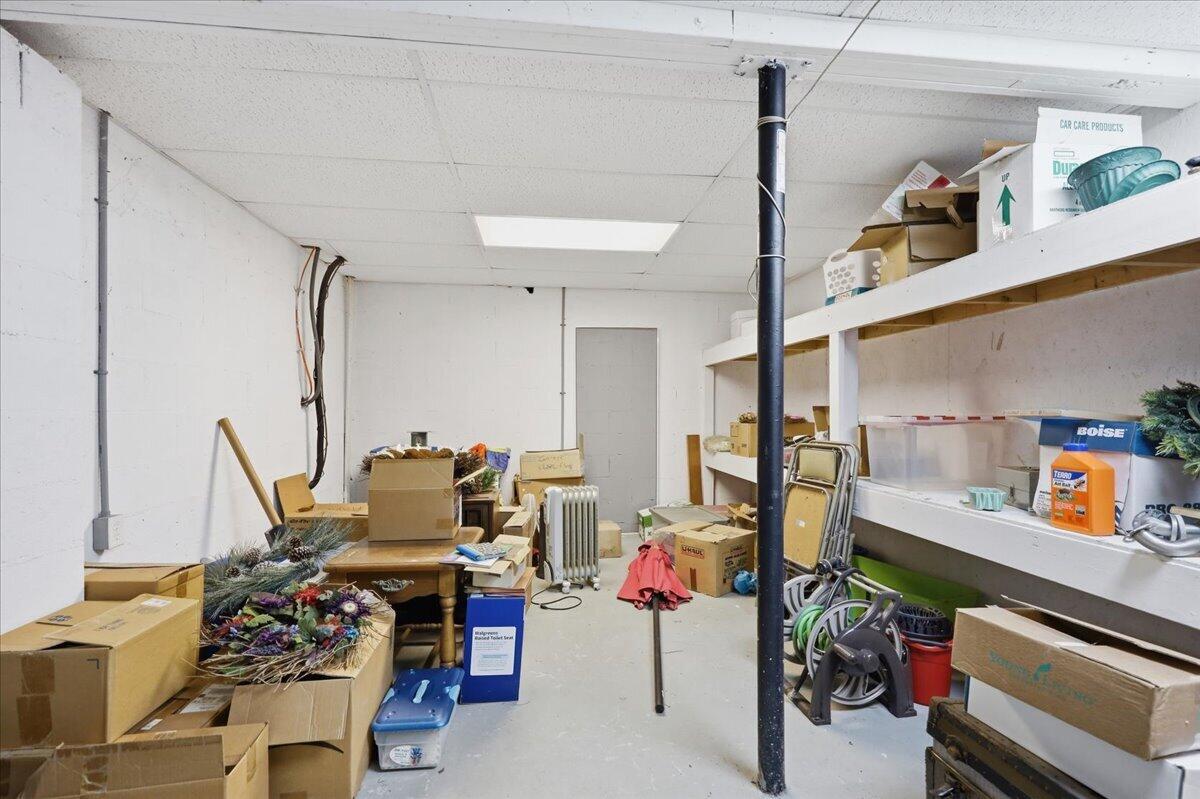 Storage room with long shelves crowded with boxes, decorations, and assorted items.