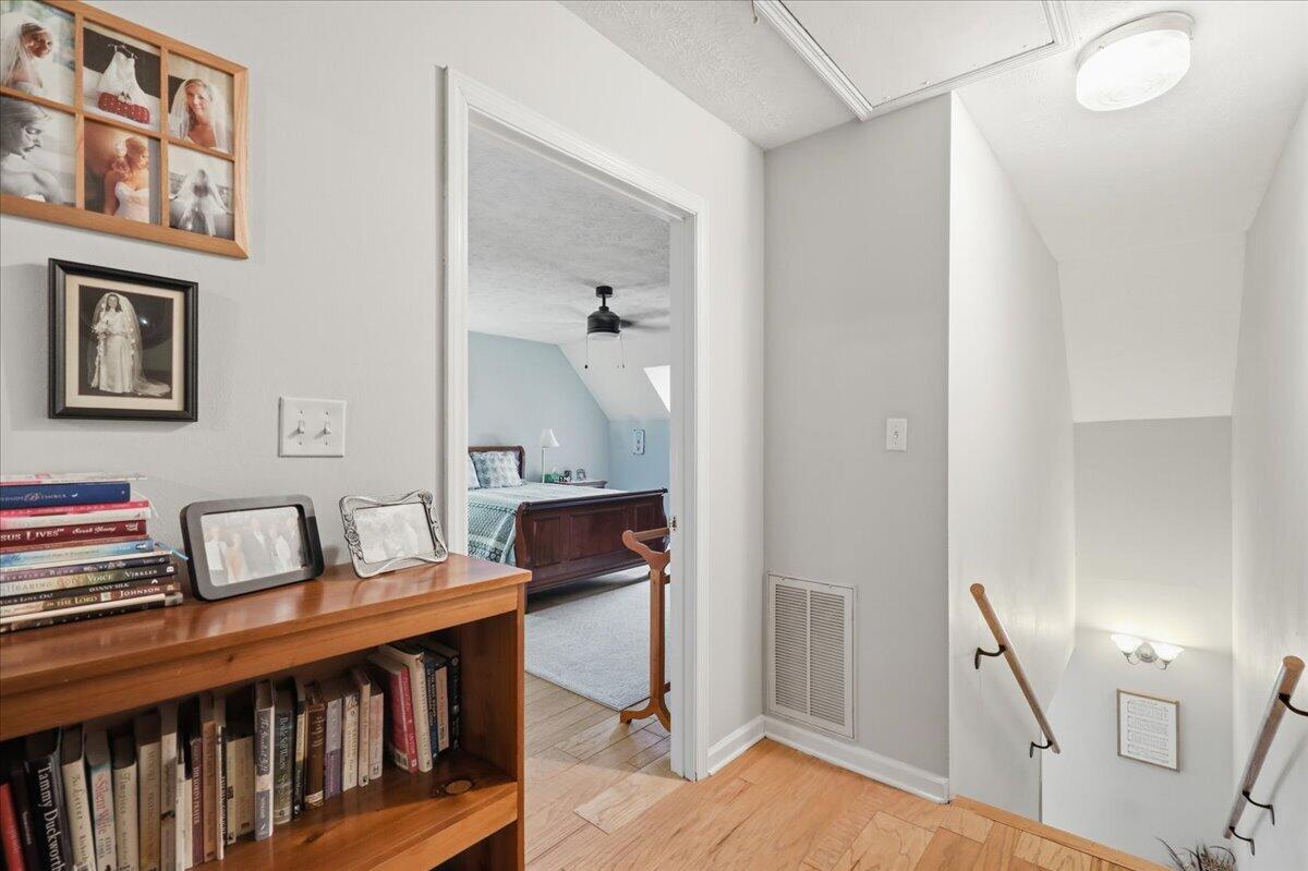Upstairs landing with a bookcase and desk, opening onto a bedroom with a blue accent wall.