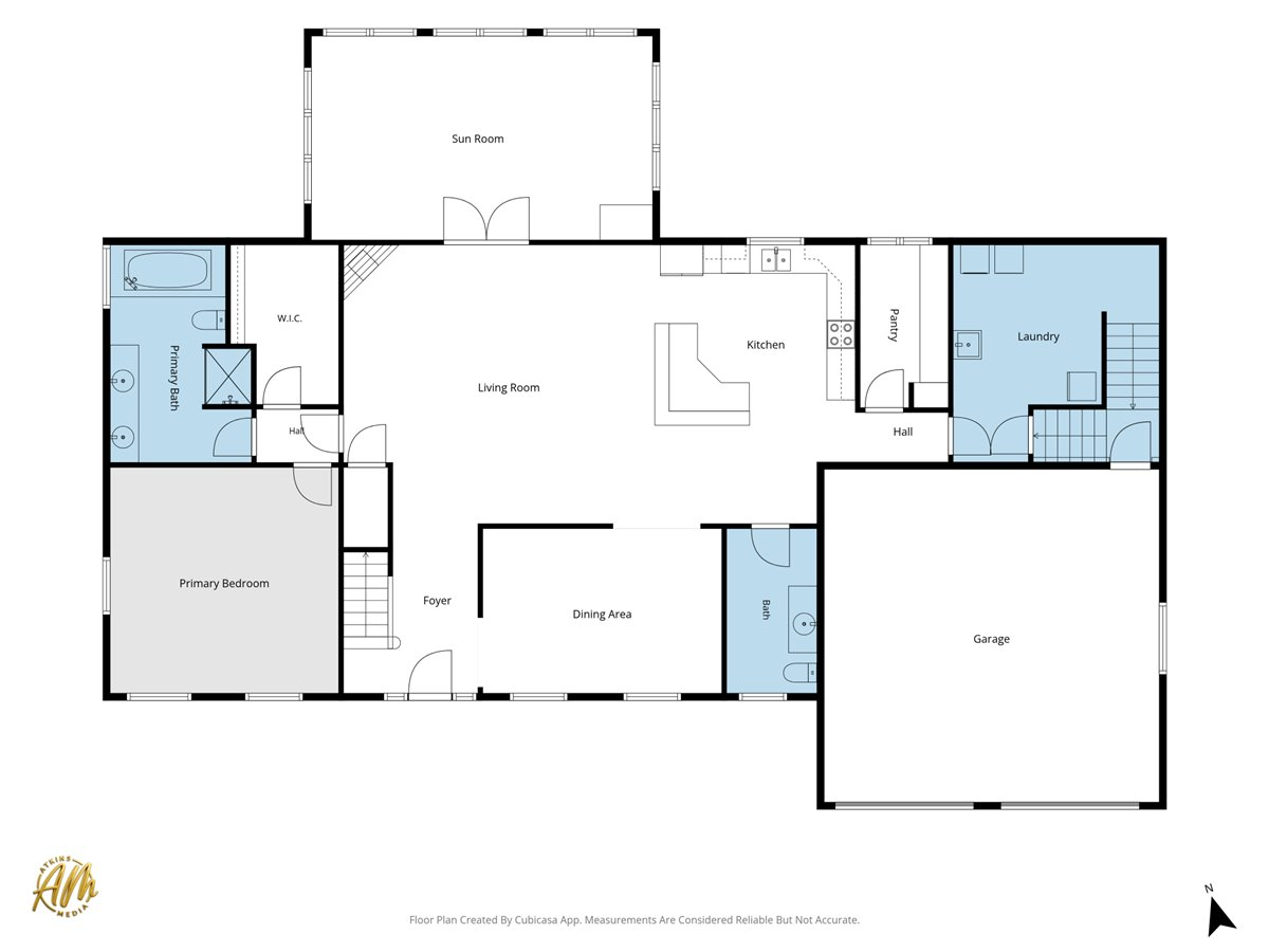 Floor plan with a sun room, open living and kitchen area, primary suite, laundry, and attached garage.