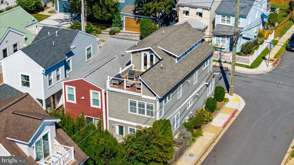 Aerial view of colorful homes lining a residential corner street.