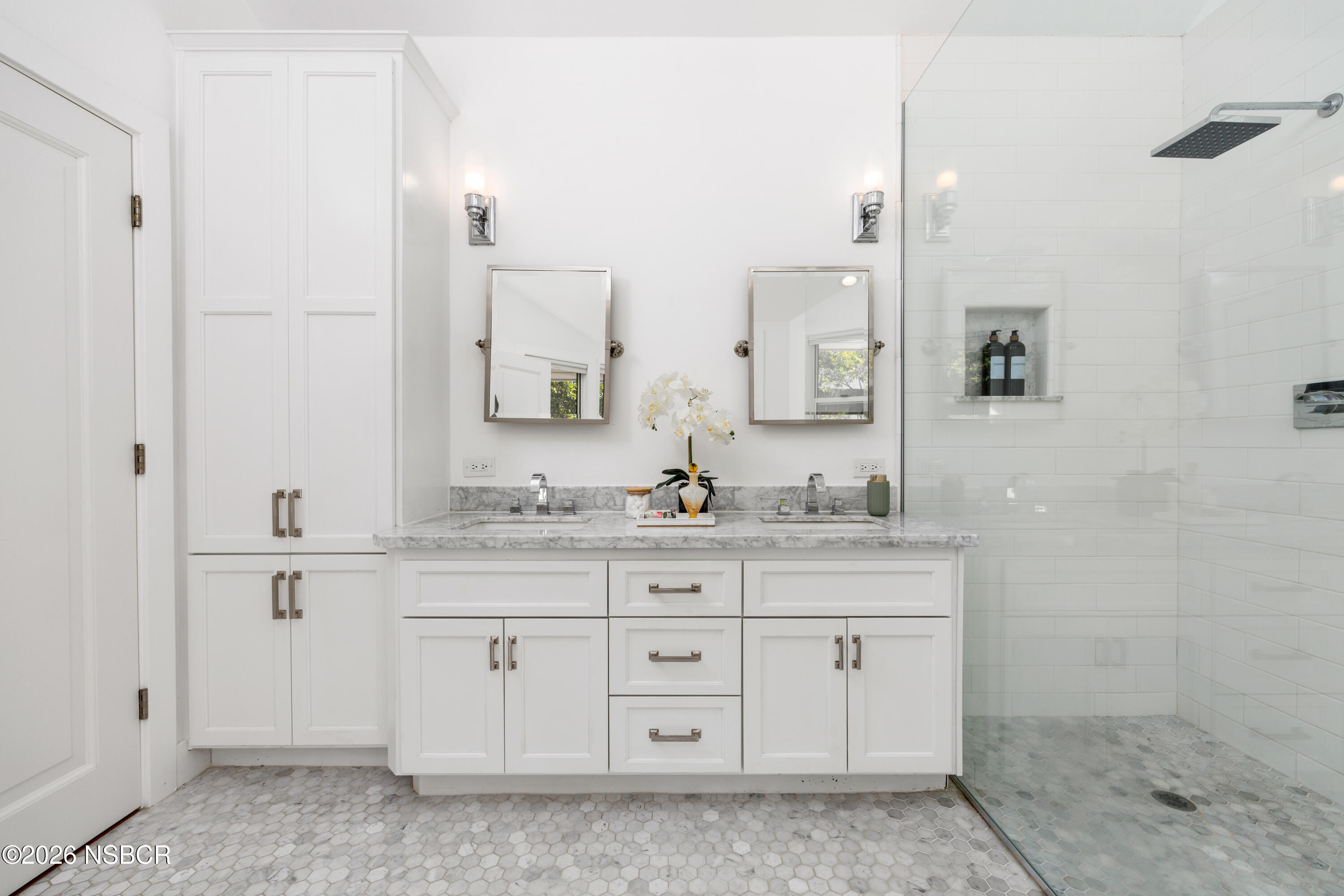 Bathroom with a white double vanity, marble countertop, and glass-enclosed tiled shower.