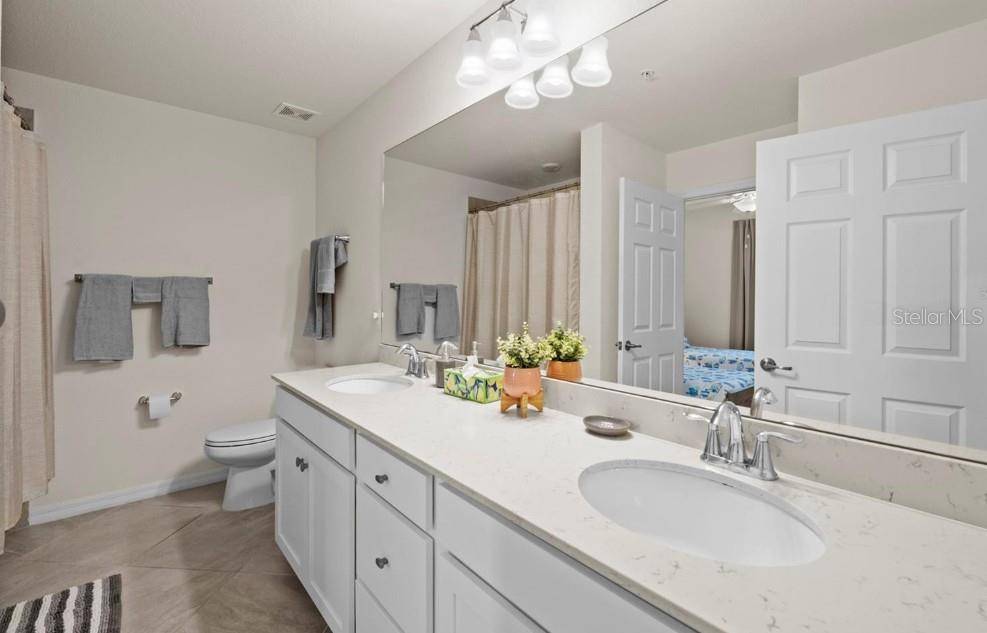 Bathroom with a long double-sink vanity and large mirror.