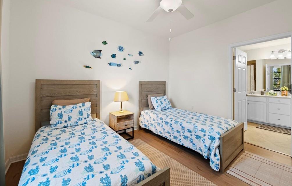 Bedroom with two patterned twin beds, fish wall decorations, and an adjoining bathroom.