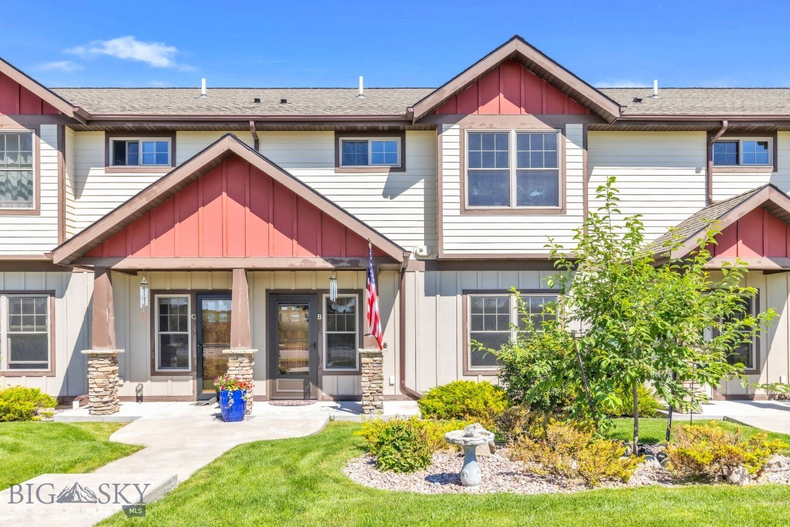 Attached homes with red gables, covered entrances, and landscaped lawns.