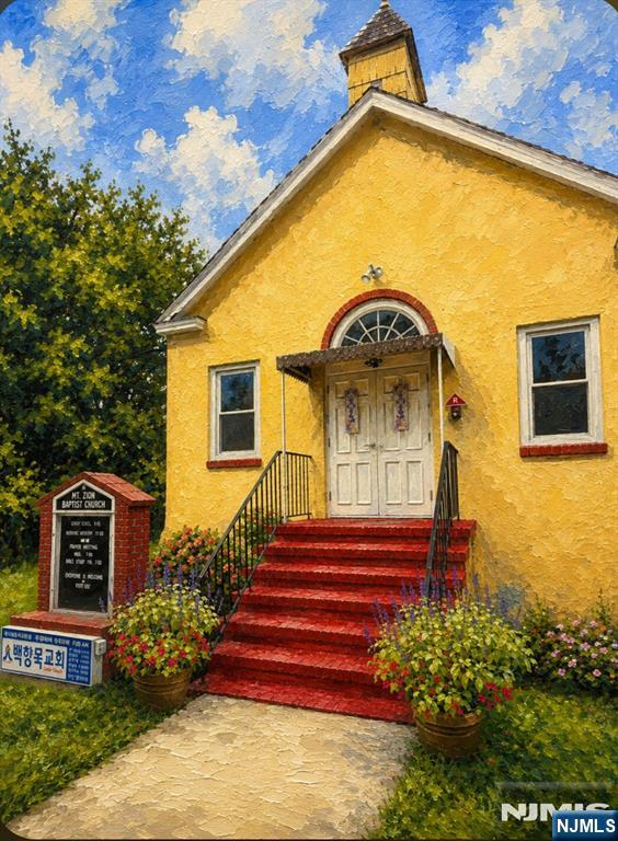 Yellow Mt. Zion Baptist Church with red steps and flower beds.