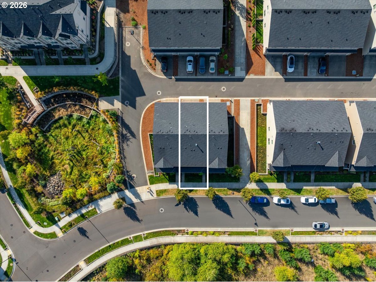 Aerial view of the outlined townhouse among neighboring homes and landscaped streets.