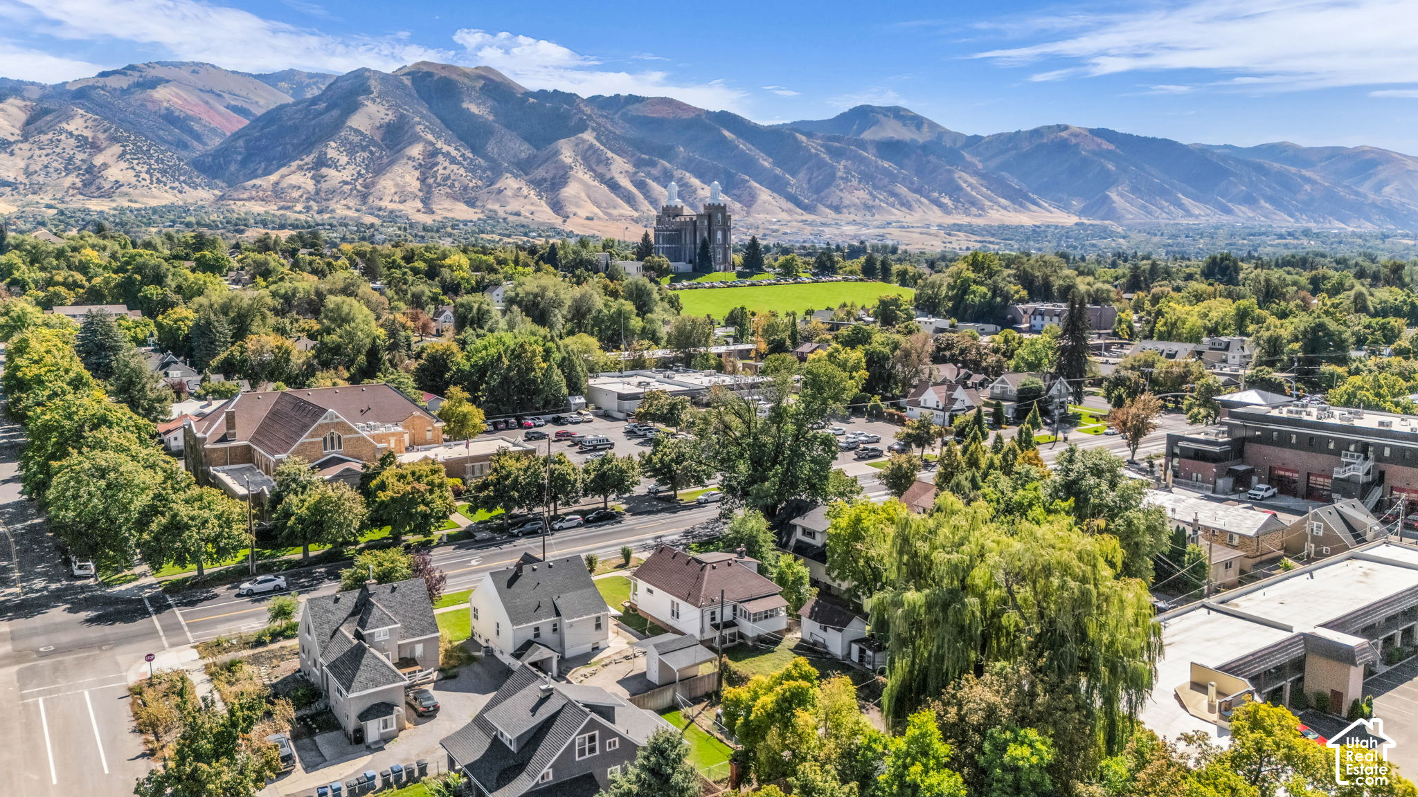 Aerial view of Logan neighborhood with mountains and the Logan Utah Temple in the distance.
