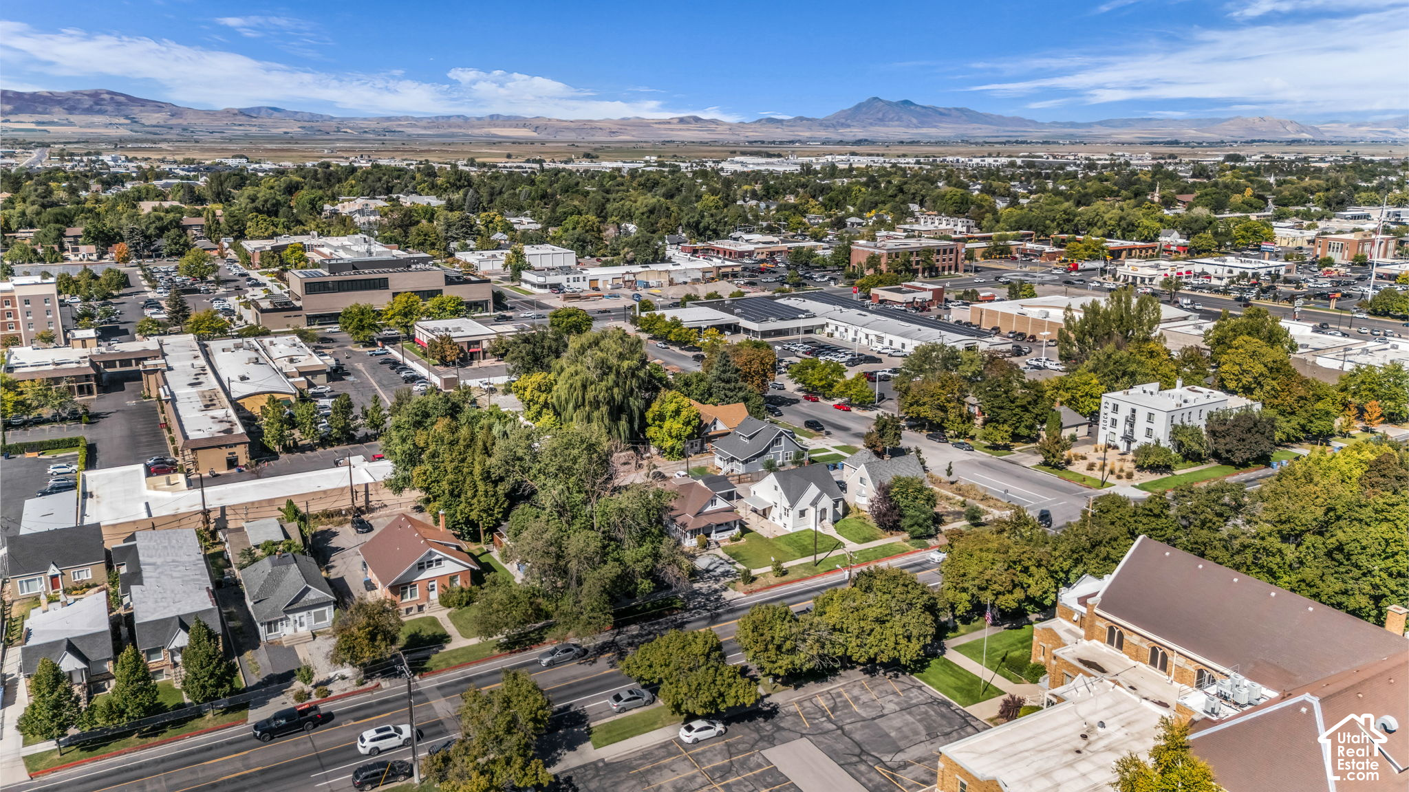 Aerial view of Logan neighborhoods and downtown, with mountains on the horizon.