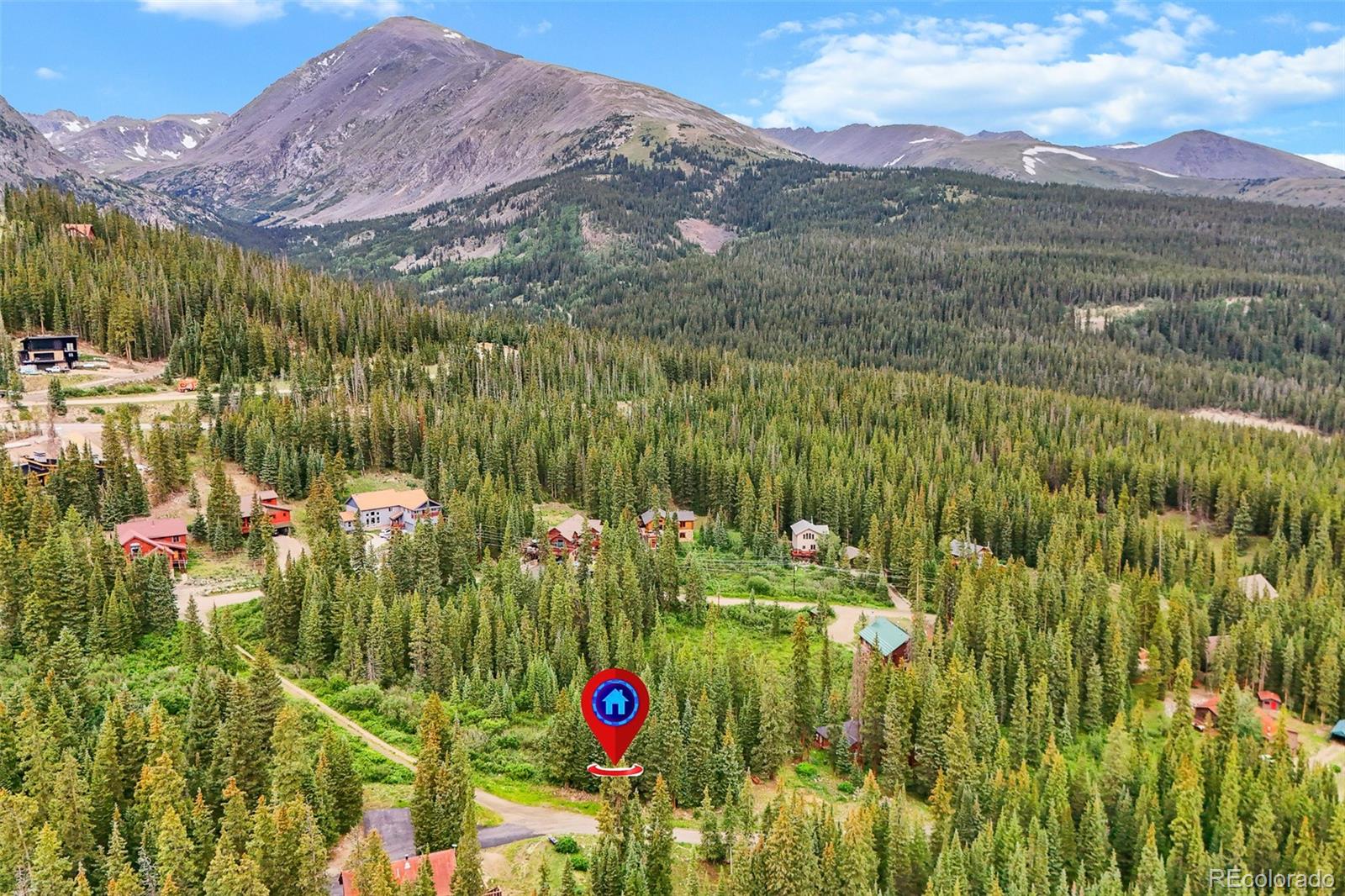 Aerial view of a forested mountain community, with scattered homes and a red location marker.