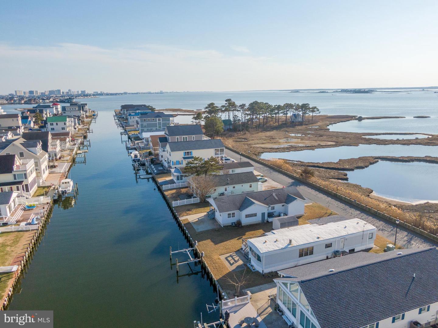 Waterfront homes line a canal beside coastal marshland.