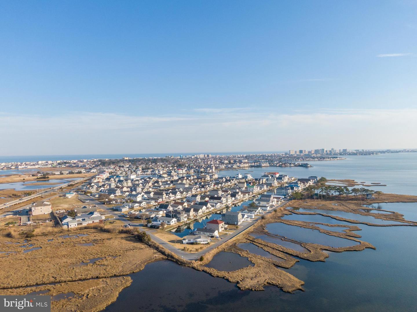 Coastal neighborhood amid tidal marshes and waterways, with the ocean on the horizon.
