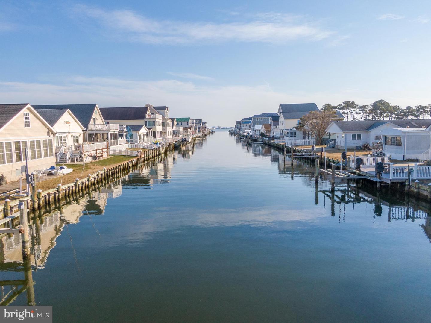 Residential canal lined with waterfront homes and docks on a clear winter day.