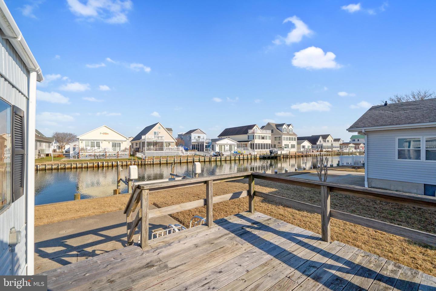 Wooden deck overlooking a canal lined with homes and docks.
