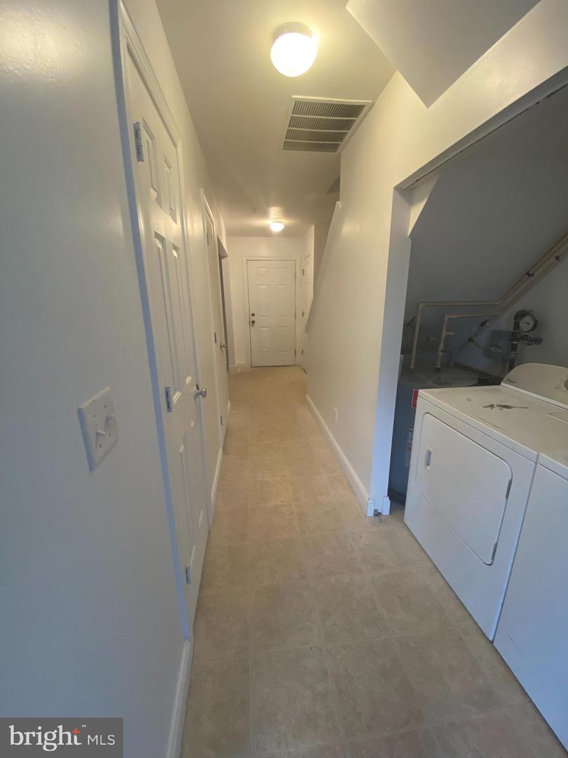 Hallway with a washer and dryer beside the utility equipment area.
