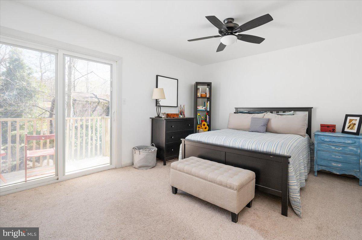 Bedroom with a dark wood bed and sliding glass doors opening to a deck.