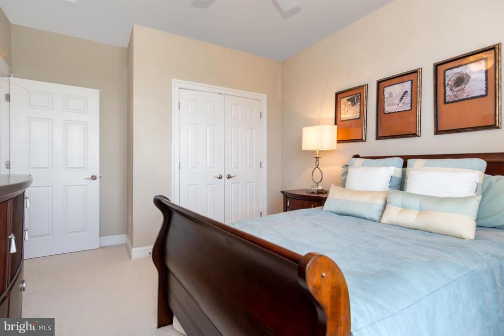 Bedroom with a dark wood sleigh bed, pale blue bedding, and framed art above the headboard.