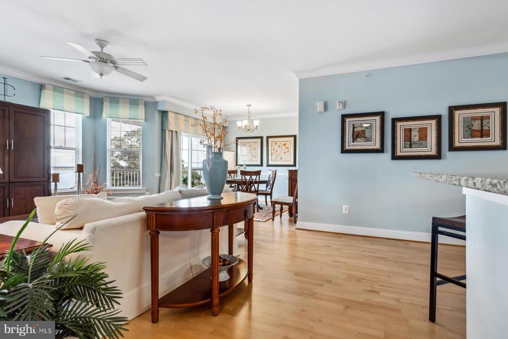 Living room with hardwood floors, blue walls, and a white sofa beside the dining area.