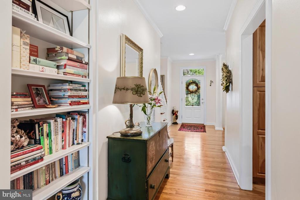 Entry hall with a book-filled built-in shelf and stained-glass front door.