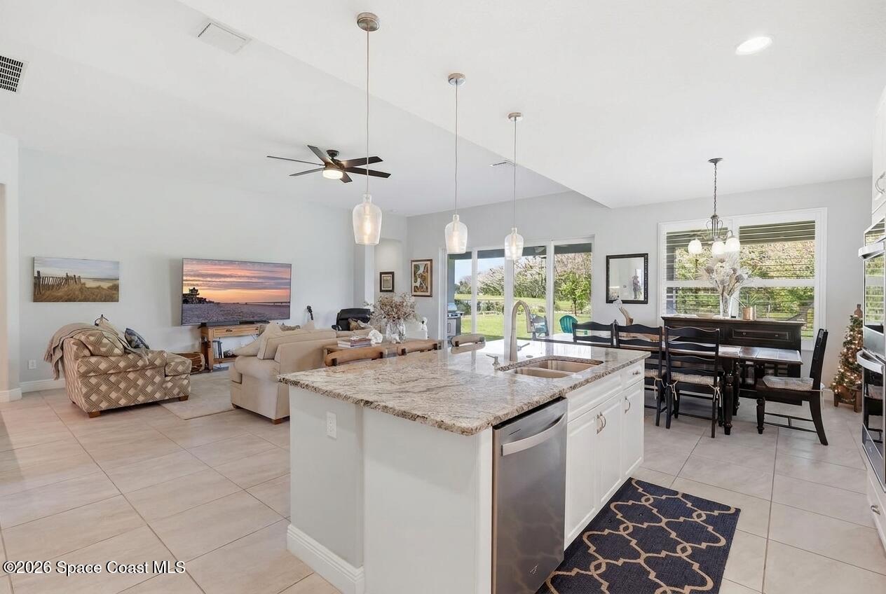 Open-plan kitchen with a stone island, adjoining living room, and dining area overlooking the yard.