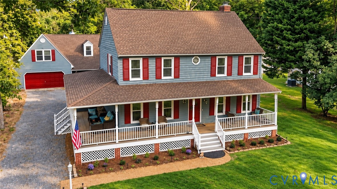 Blue two-story house with red shutters, a broad white-railed porch, and an attached garage.
