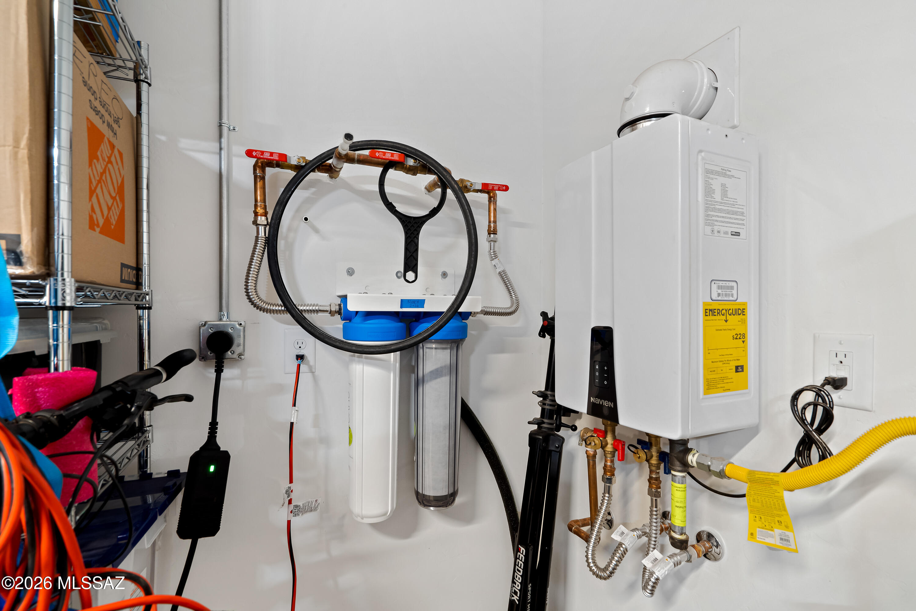 Utility room with a Navien tankless water heater and a multi-stage water filtration system.
