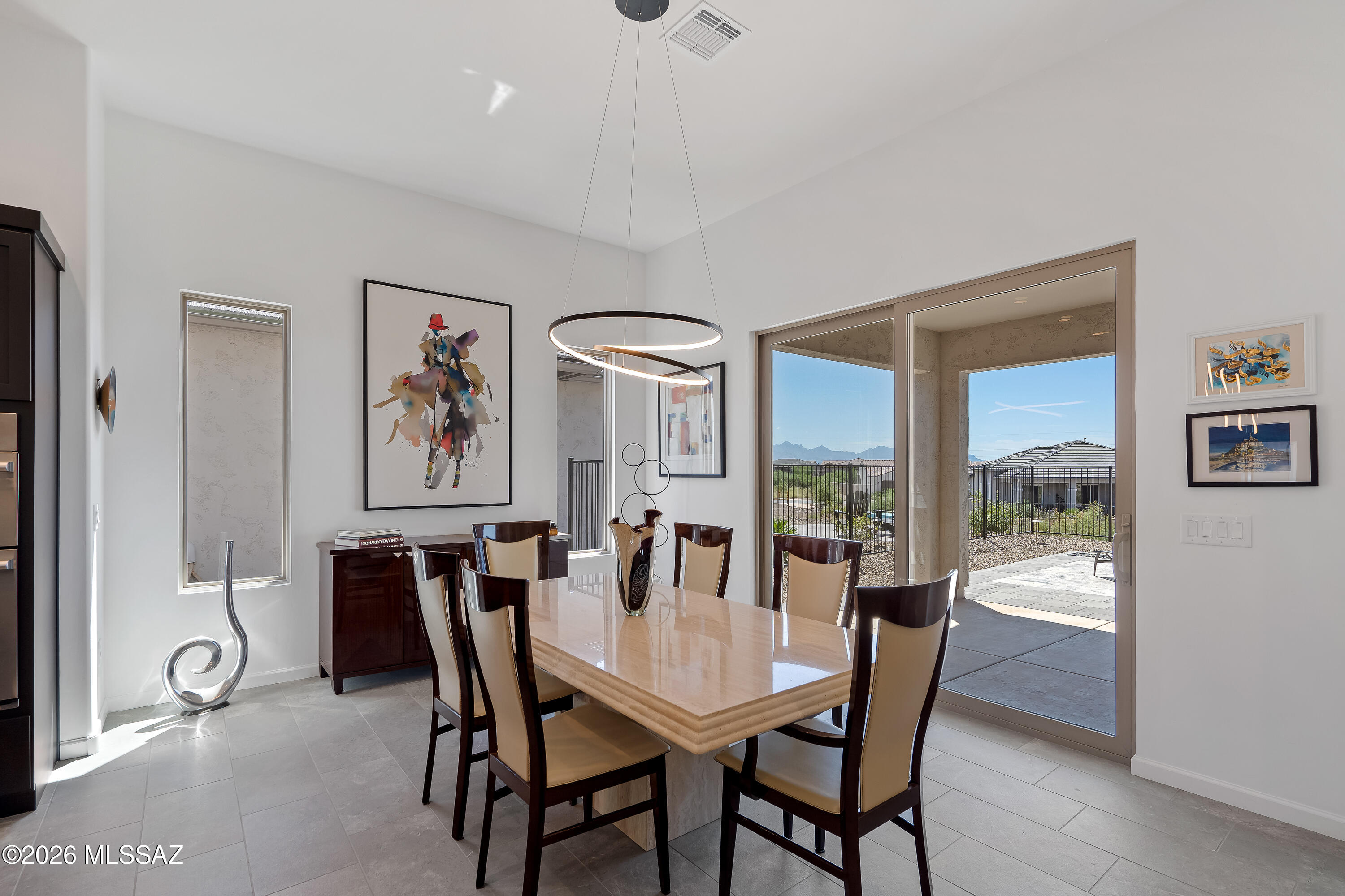 Dining room with a stone table and sliding glass doors opening to a mountain view.