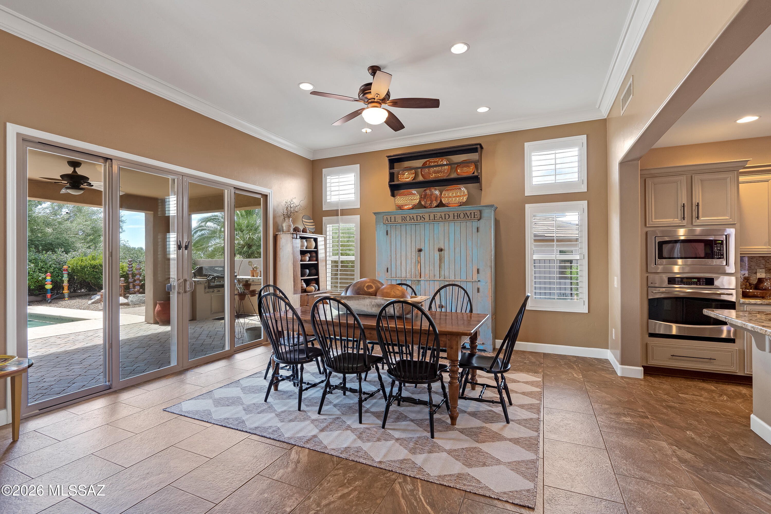 Dining area with a wooden table, sliding glass doors, and a distressed blue cabinet.
