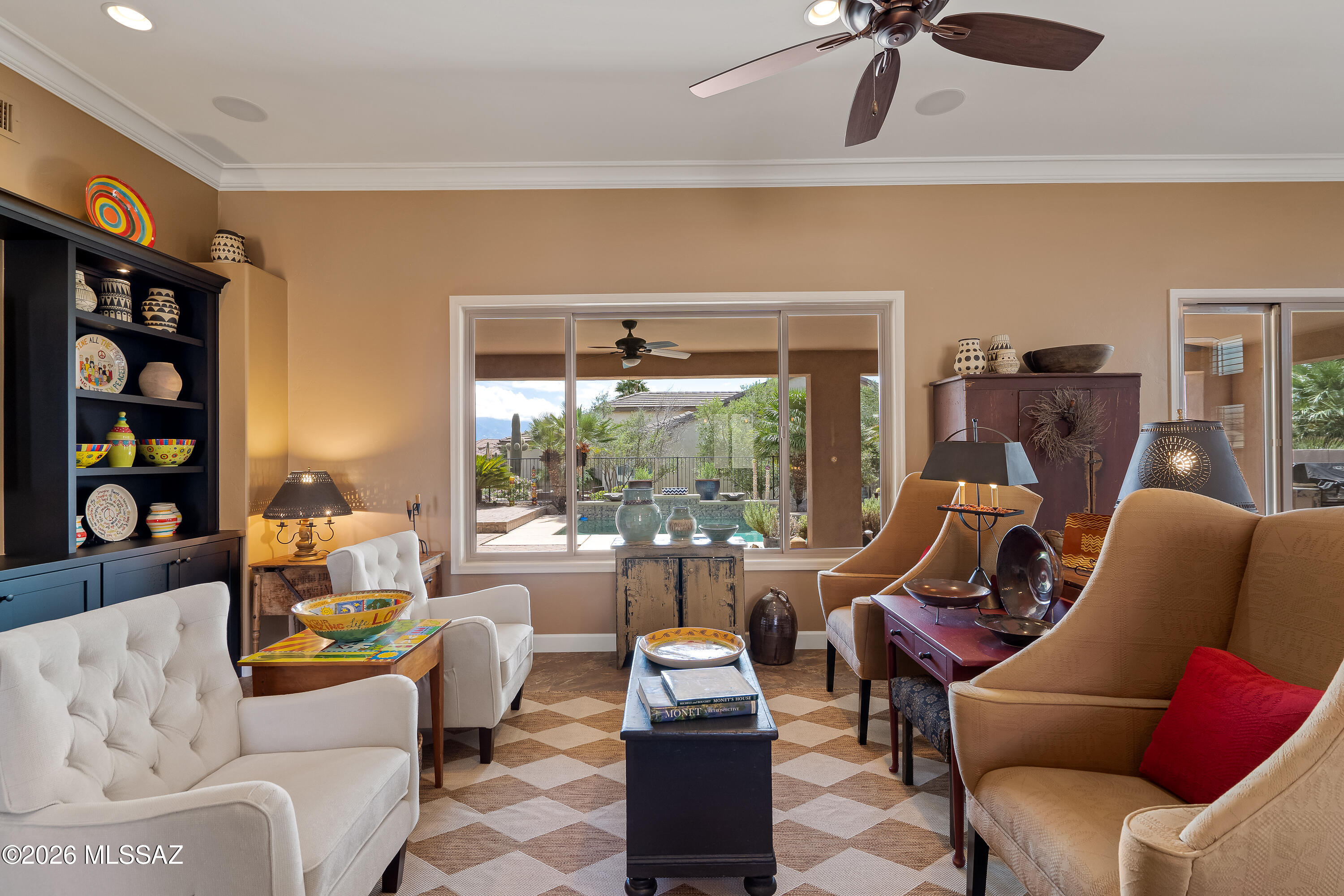 Furnished living room with colorful Southwestern decor and sliding doors overlooking a pool.
