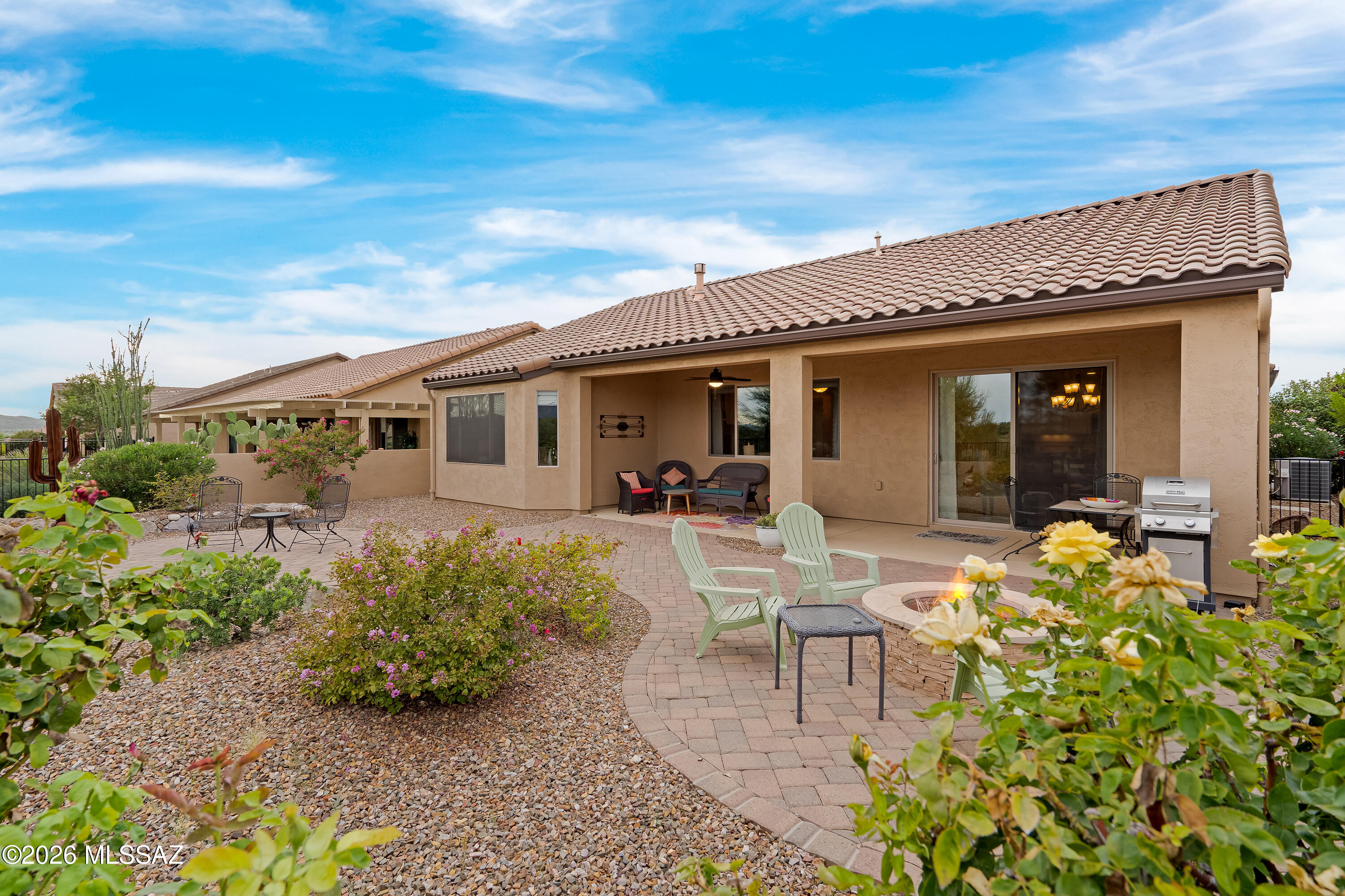Rear patio with a covered seating area, paver courtyard, fire pit, and barbecue grill.
