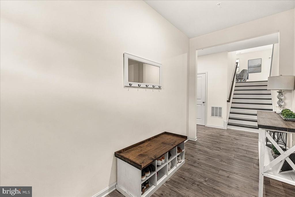 Entryway with a shoe-storage bench and staircase leading to the upper level.