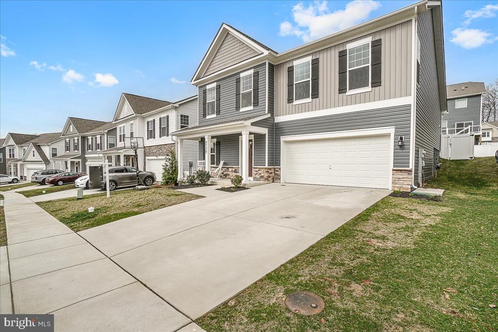 Gray two-story house with a covered porch, stone accents, and an attached two-car garage.