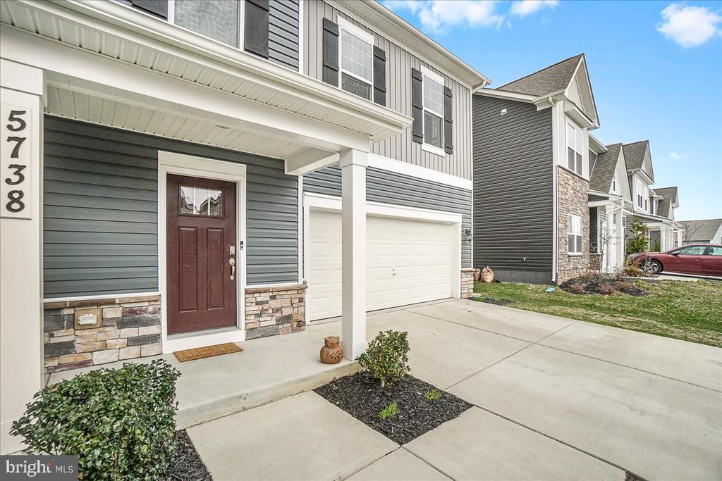 Gray two-story home with a covered entry, stone accents, and an attached double garage.
