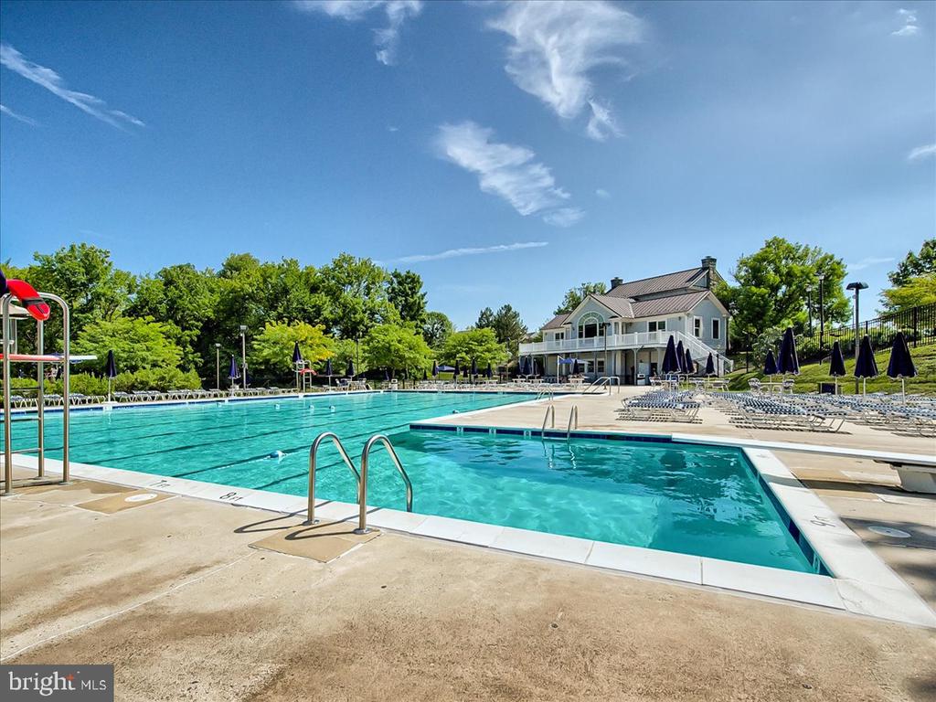 Community pool and adjoining smaller pool beside a two-story clubhouse.