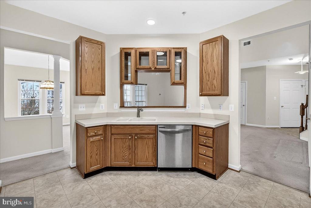 Kitchen with oak cabinets, a stainless steel dishwasher, and a pass-through window.