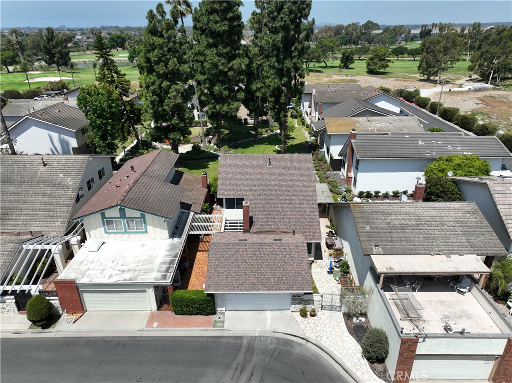 Aerial view of 12341 Glacier, with neighboring homes and a green golf course beyond.
