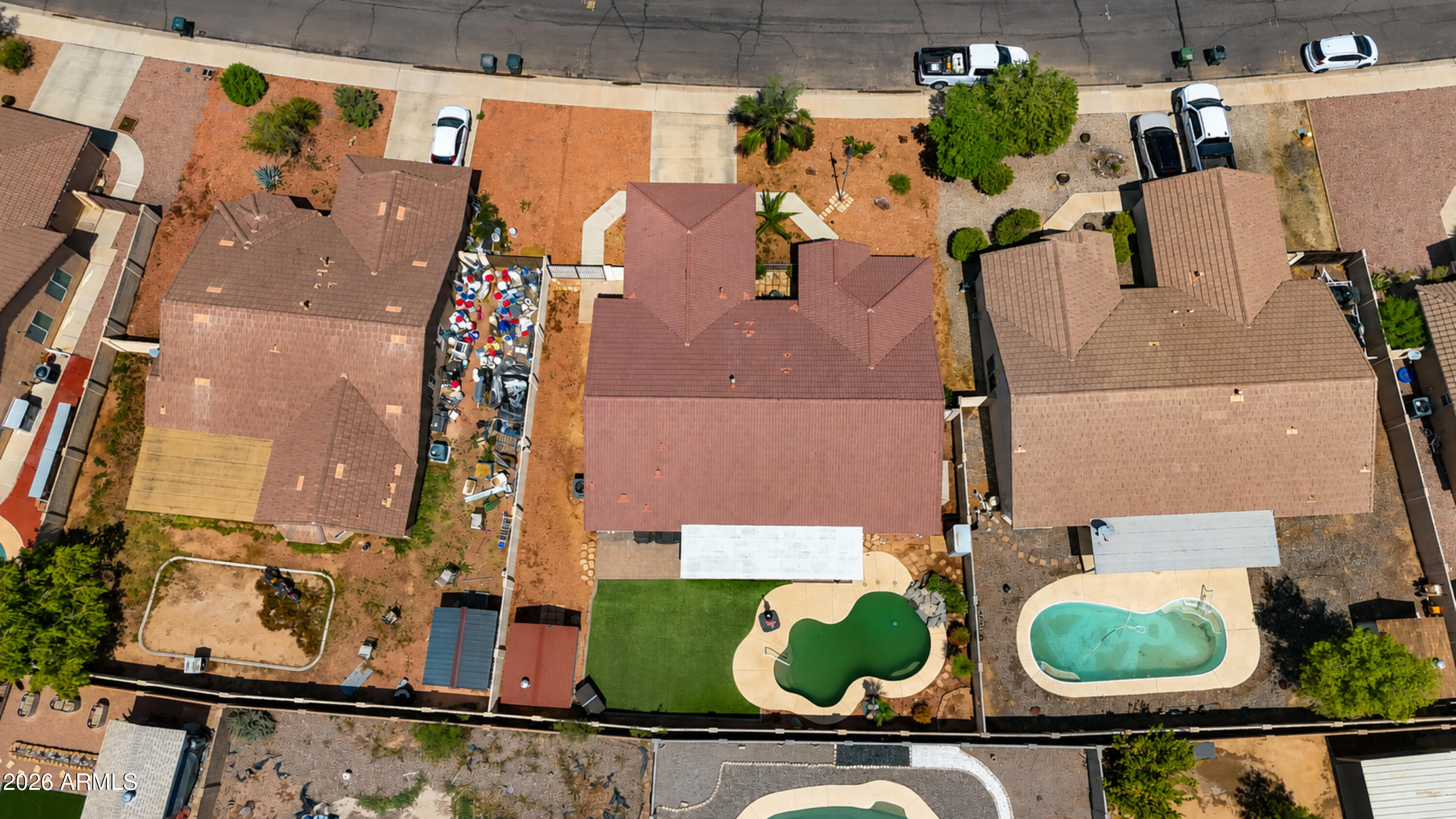 Aerial view of the home with a swimming pool, artificial turf, and covered patio.
