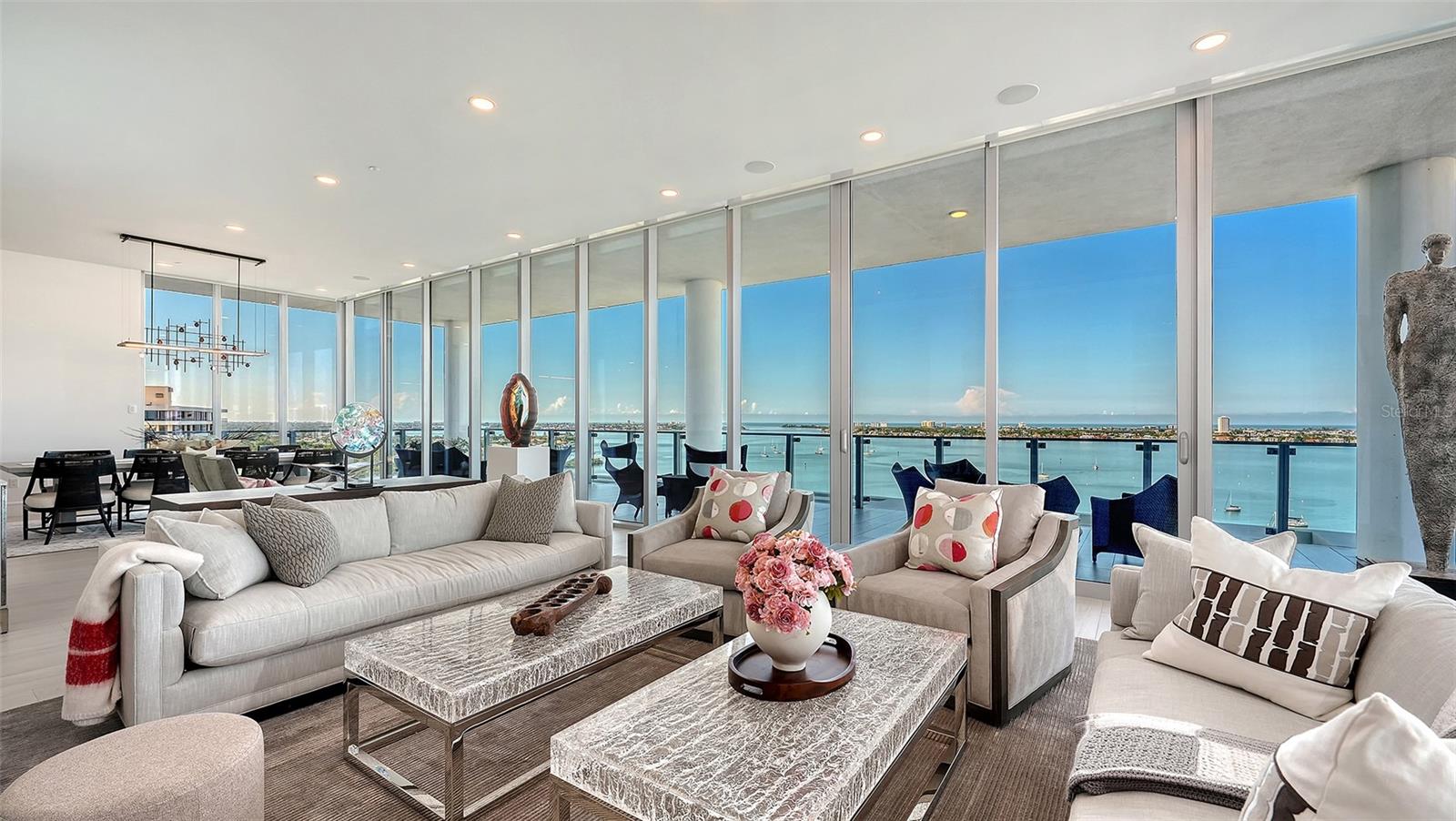 Furnished living room with floor-to-ceiling windows overlooking Sarasota Bay.