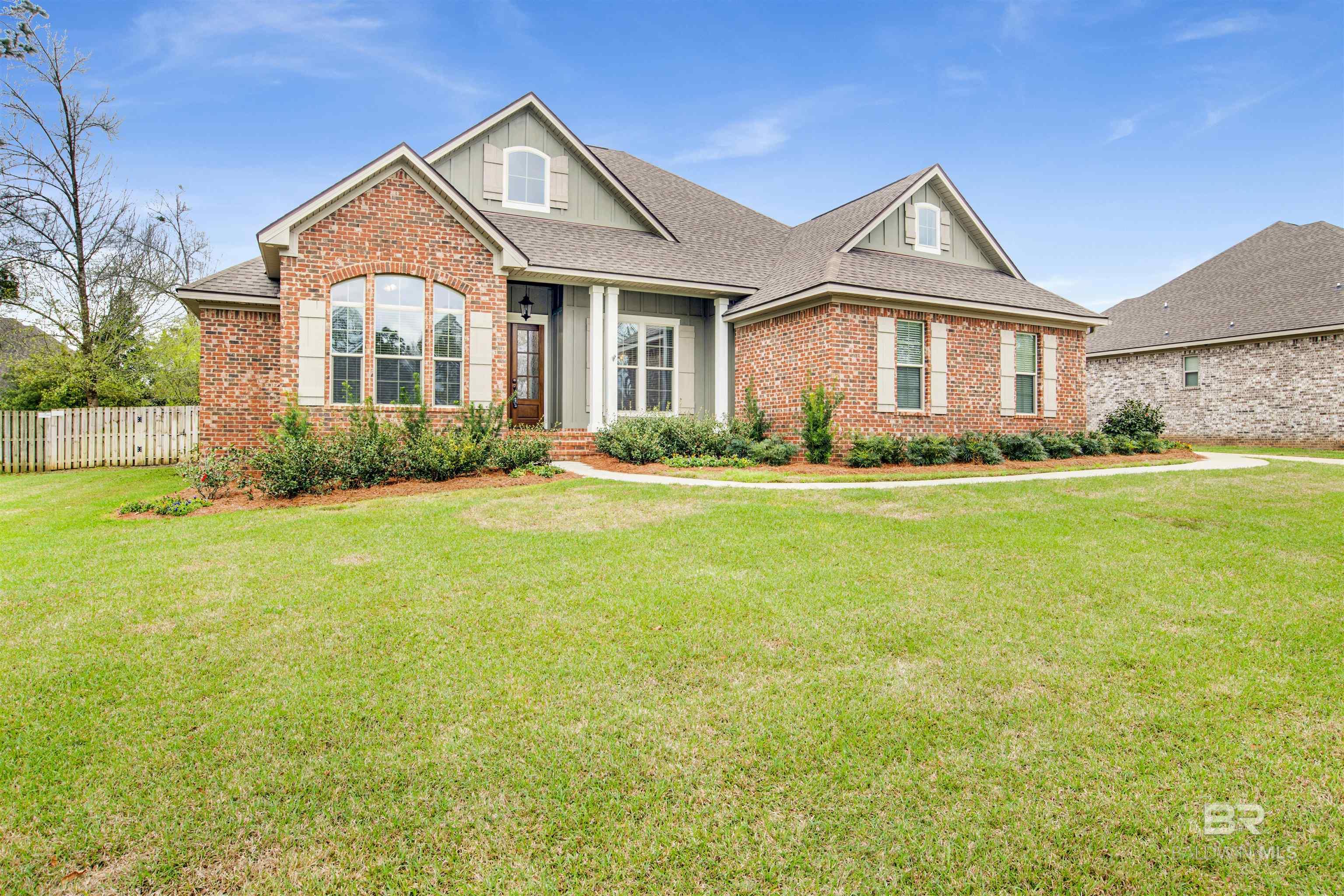 Red brick house with gray siding, multiple gables, and a broad front lawn.