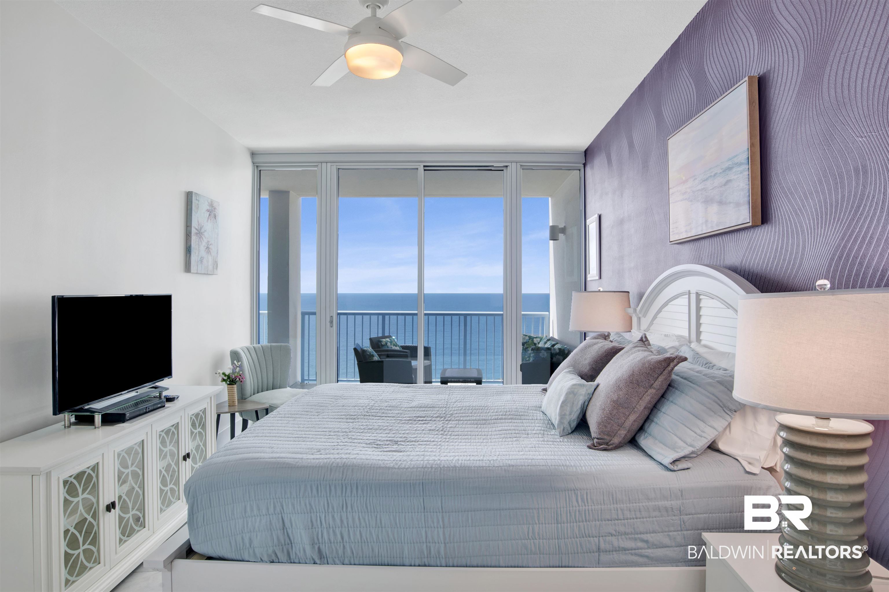 Bedroom with a king-size bed and sliding doors overlooking the Gulf from a balcony.