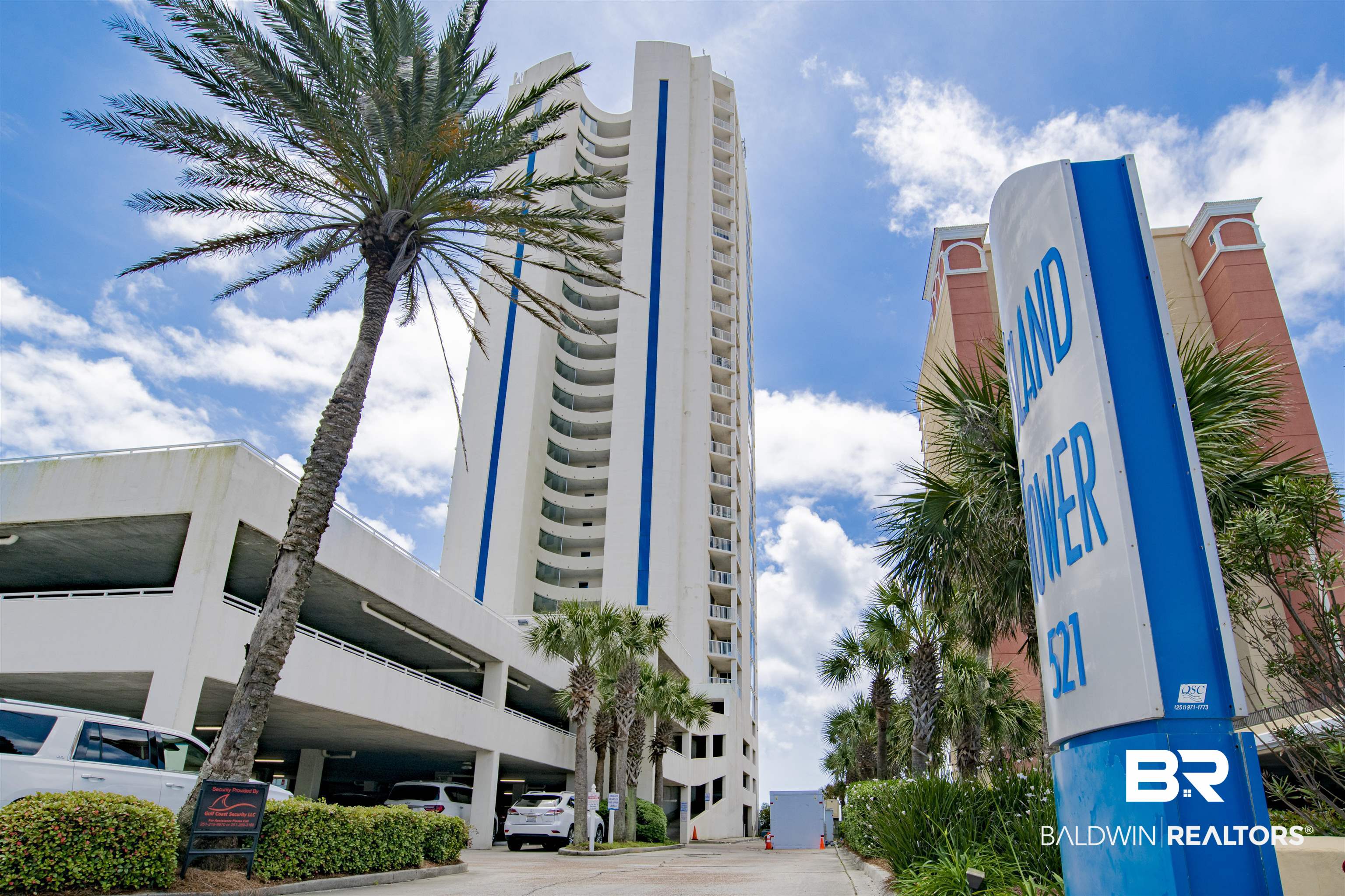 Sandpiper condominium tower with blue accents, palm trees, and a 521 roadside sign.