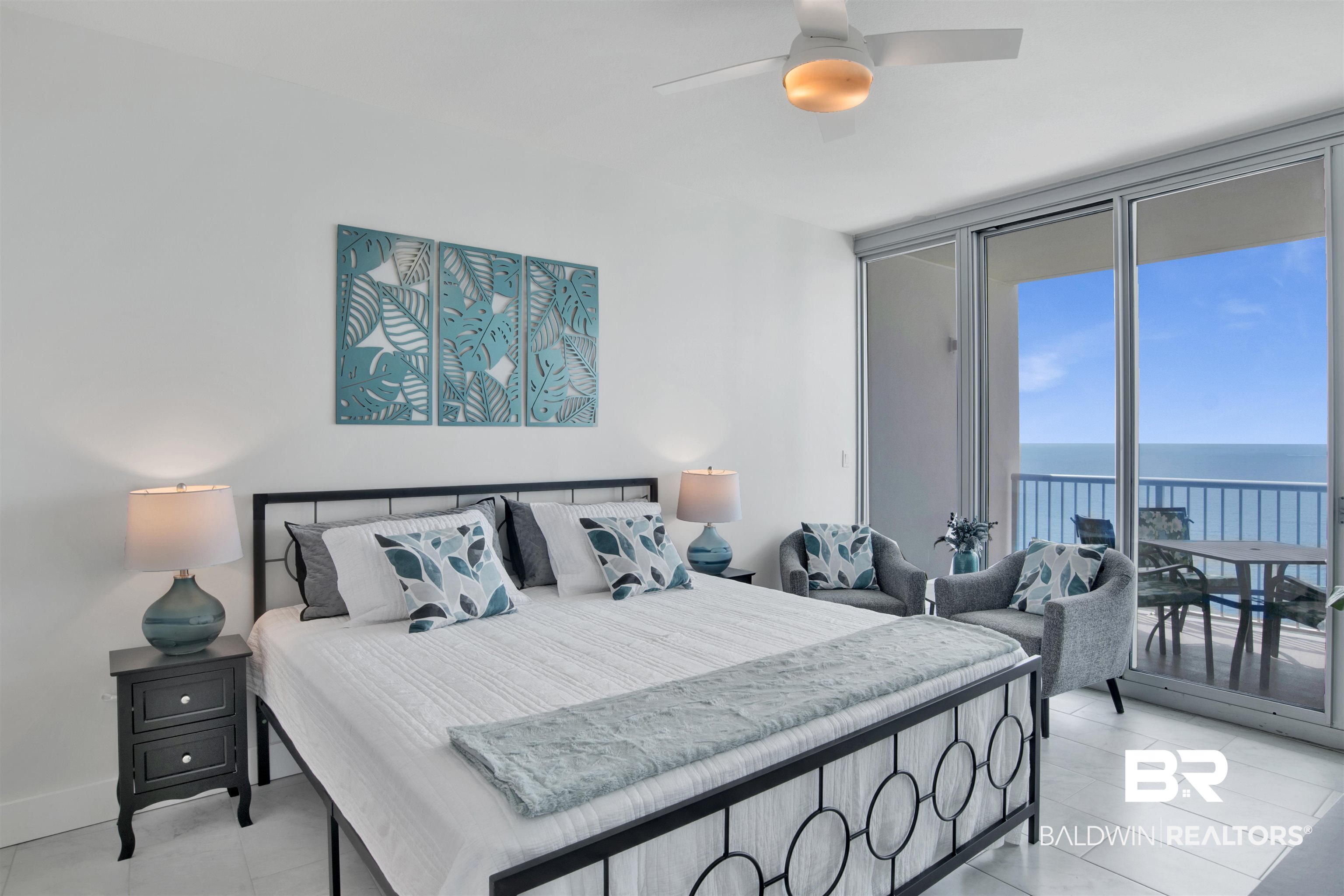 Bedroom with a king bed and sliding glass doors overlooking the ocean.