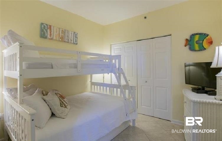 Bedroom with white bunk beds, yellow walls, and colorful fish wall decor.