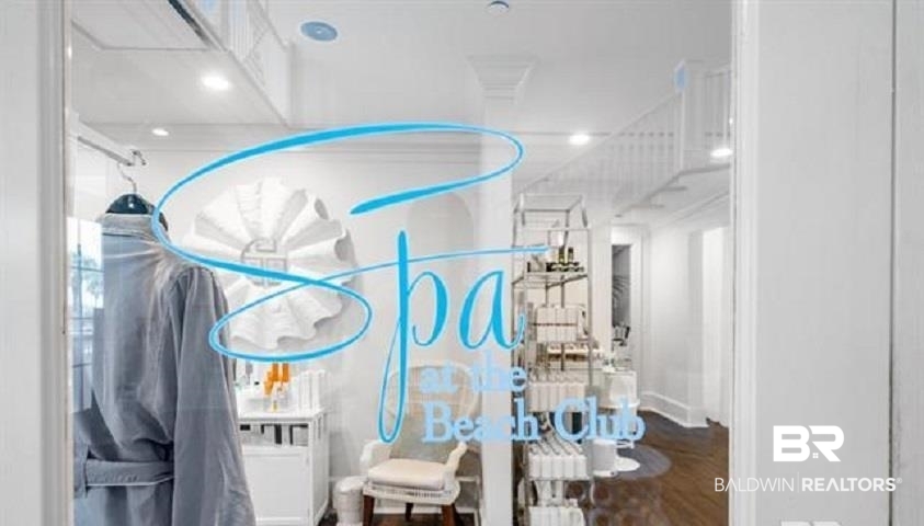 The Beach Club spa with a treatment chair, hanging robes, and shelves of spa products.