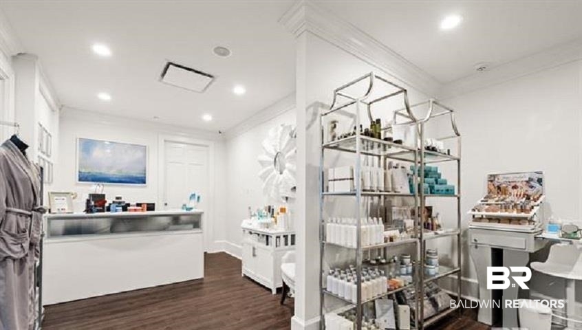 Bright spa retail room with a white reception counter and shelves of skincare products.