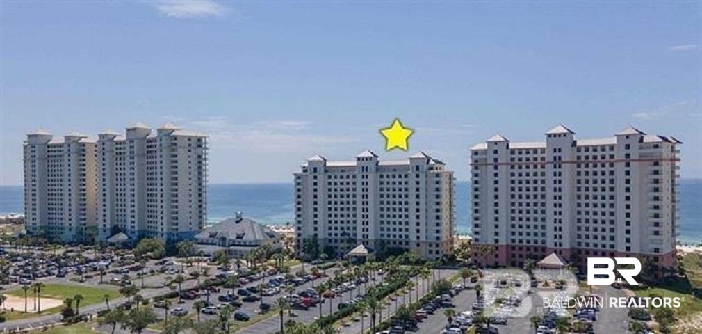 Beachfront condominium towers beside the Gulf, with a yellow star marking the center tower.